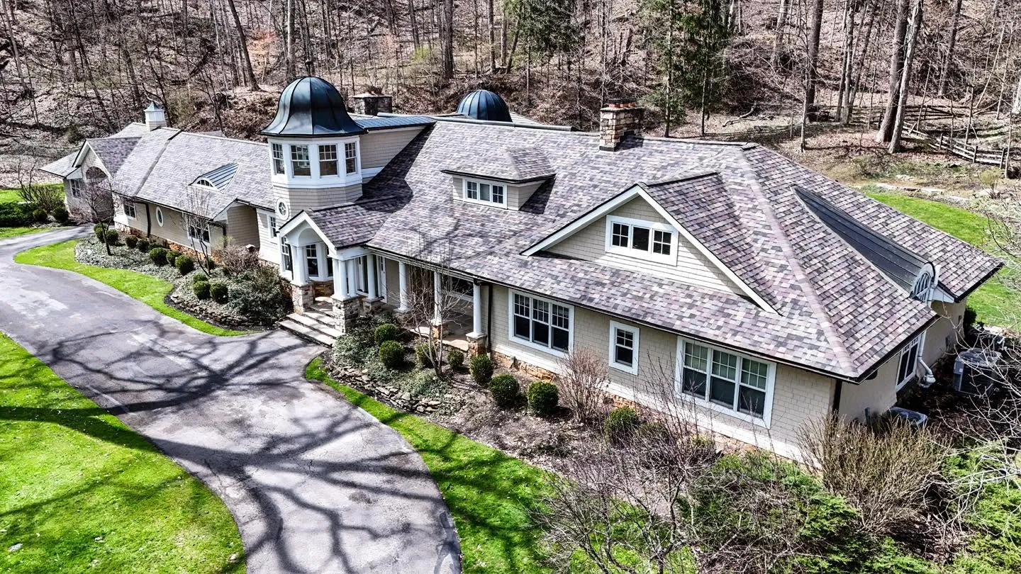 Aerial view of a custom home with a designer shingle roof