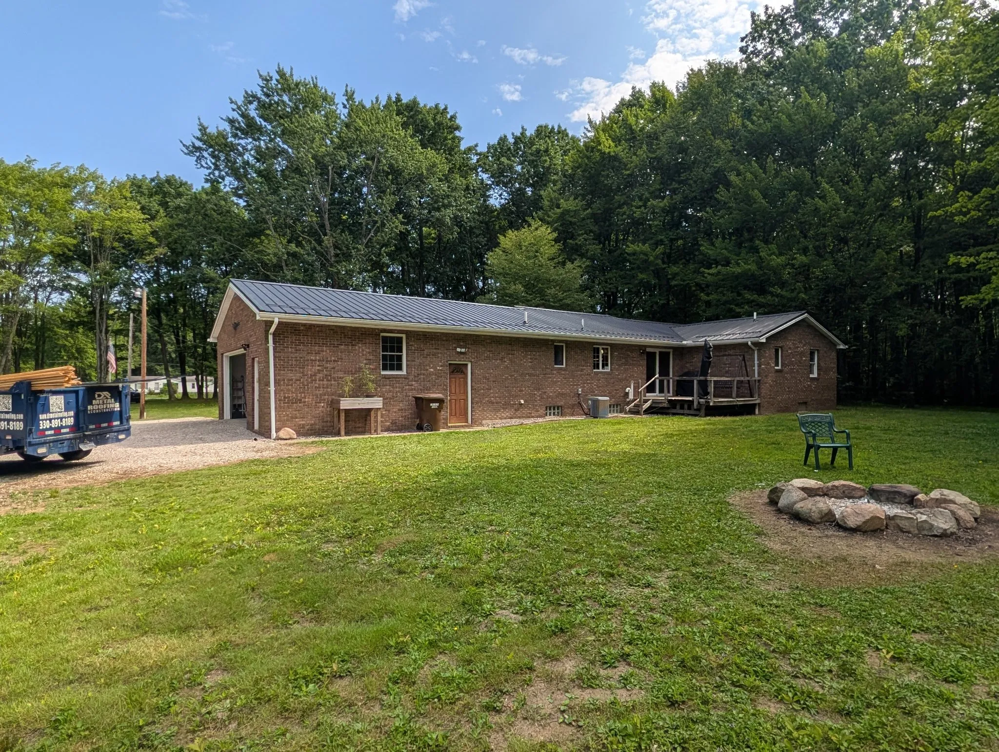 Charcoal standing seam metal roof on a brick ranch